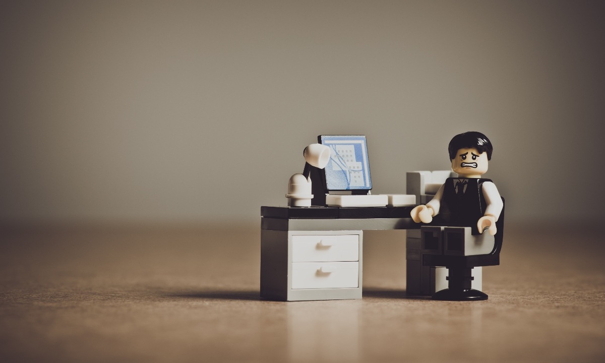 A toy figurine of a man sitting at a desk and think about Communication Importants