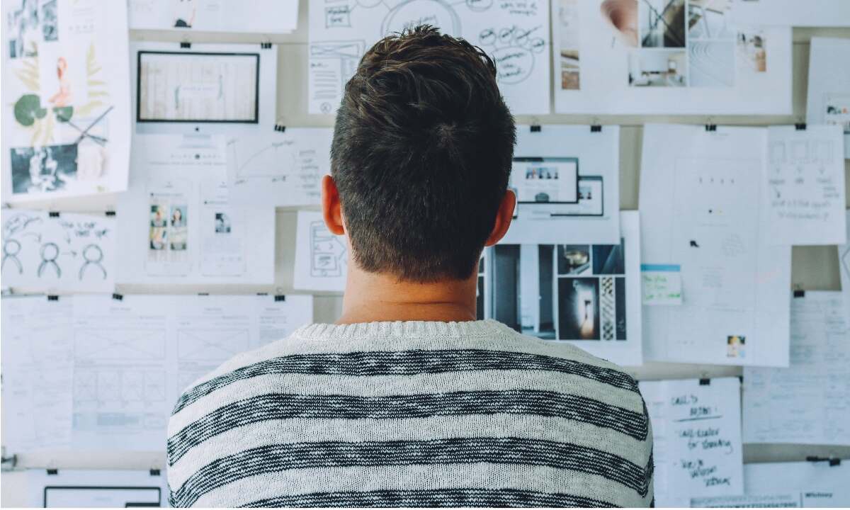 a man looking at a bulletin board and think about Communication Importants